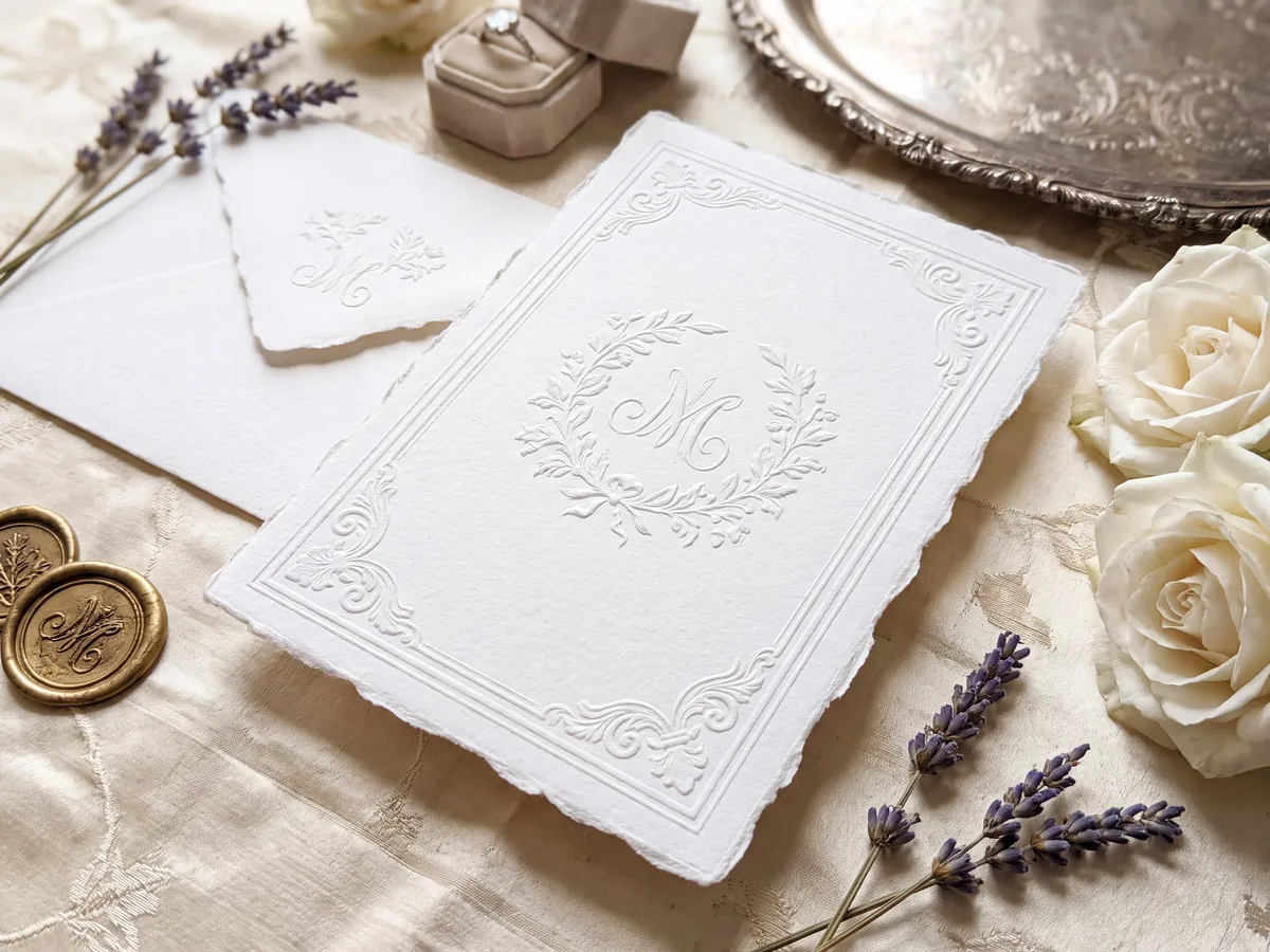 Blind letterpress invitation with embossed wreath monogram